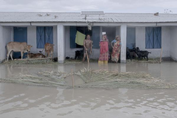 Image from Flood Survival People -  A family stands outside their flooded house. 
