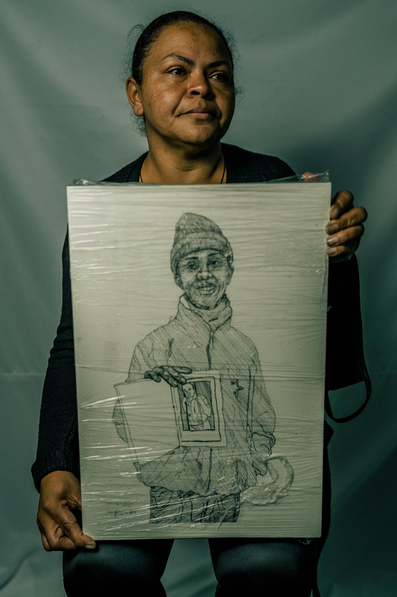 The Washington Post: Resistencia  - Dolores stands with a drawing of her son, Duban, who went missing in June of 2021, during a...