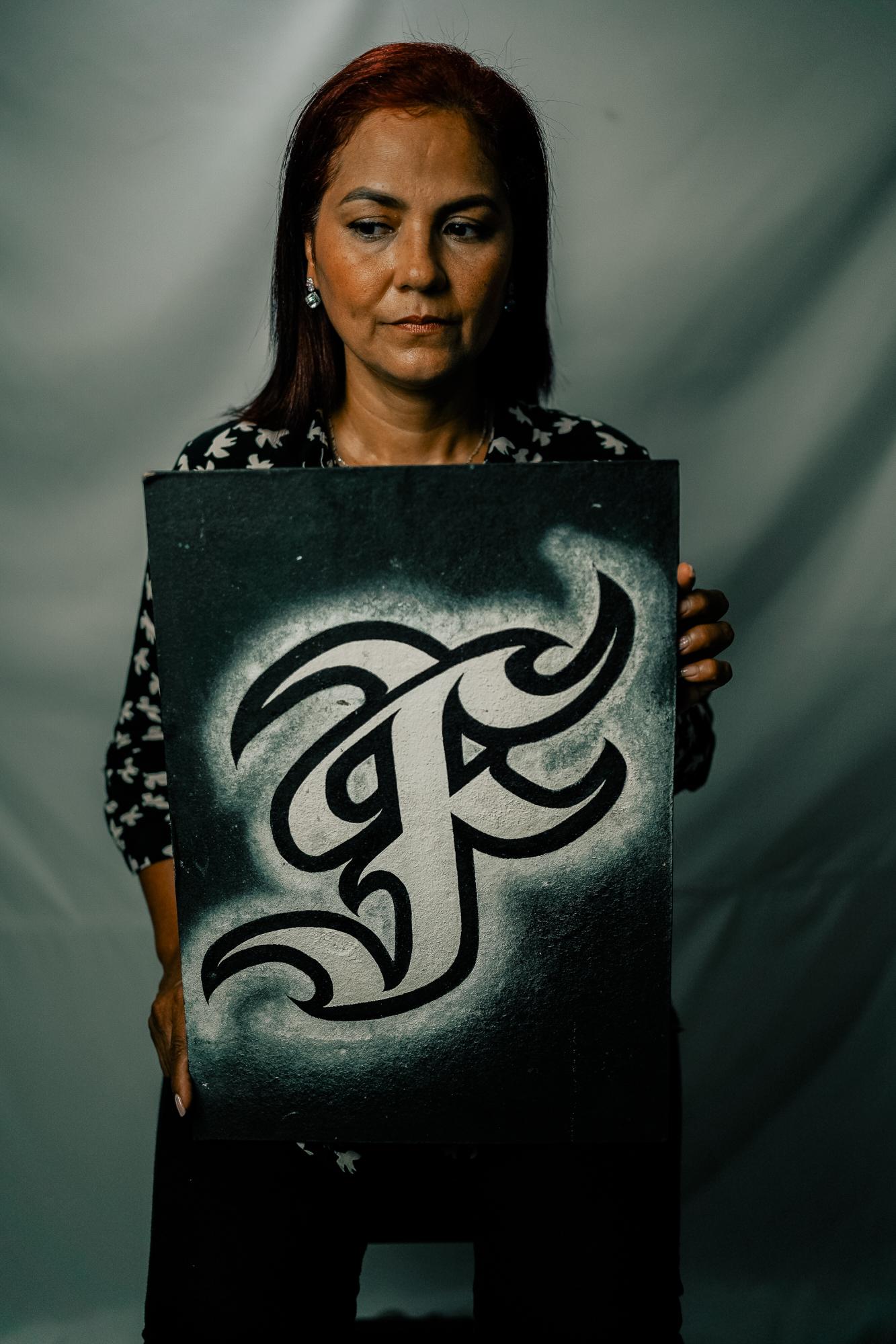 The Washington Post: Resistencia  - Laura poses with a sign that says “F”, for “Flex.”  Laura’s son, Nicolás Guerrero, was a graffiti...