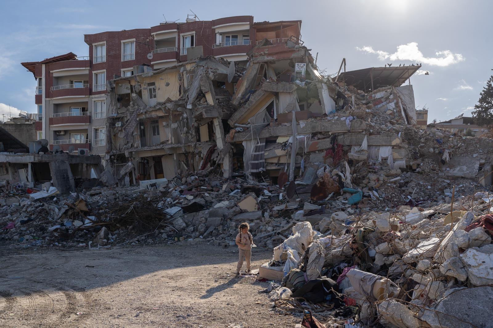 Hazar stands outside a collapse...lding collapsed. Antakya Turkey