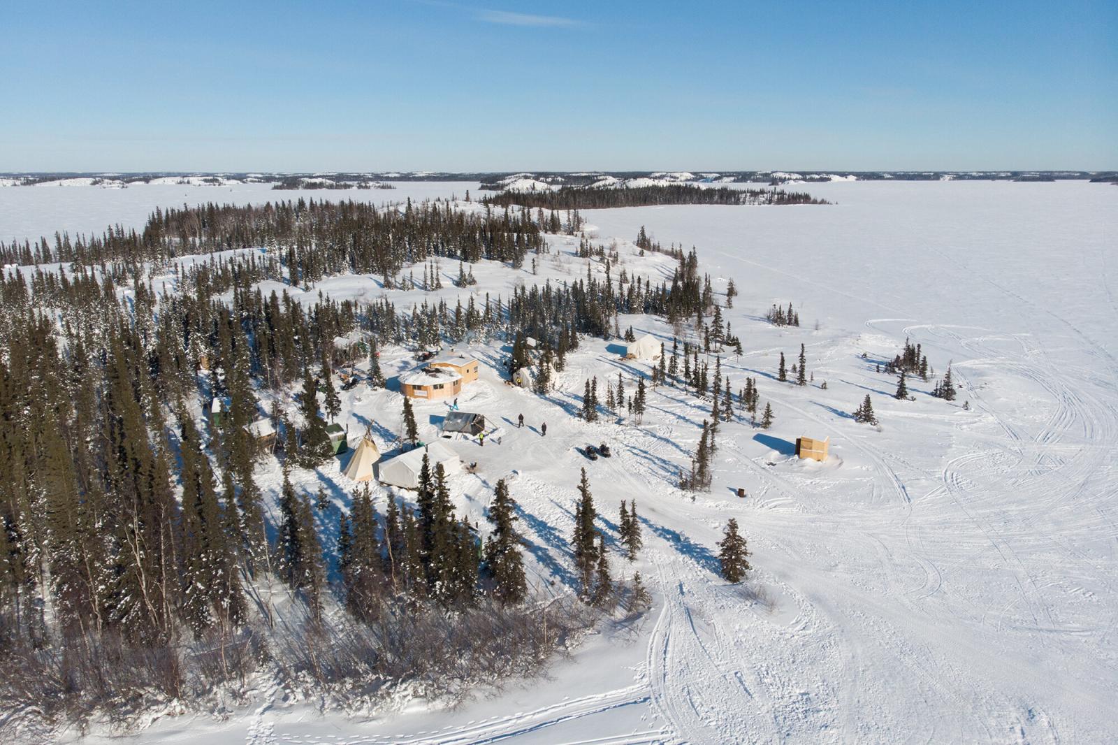 An aerial view of a Dene camp h...ting with the land and culture.