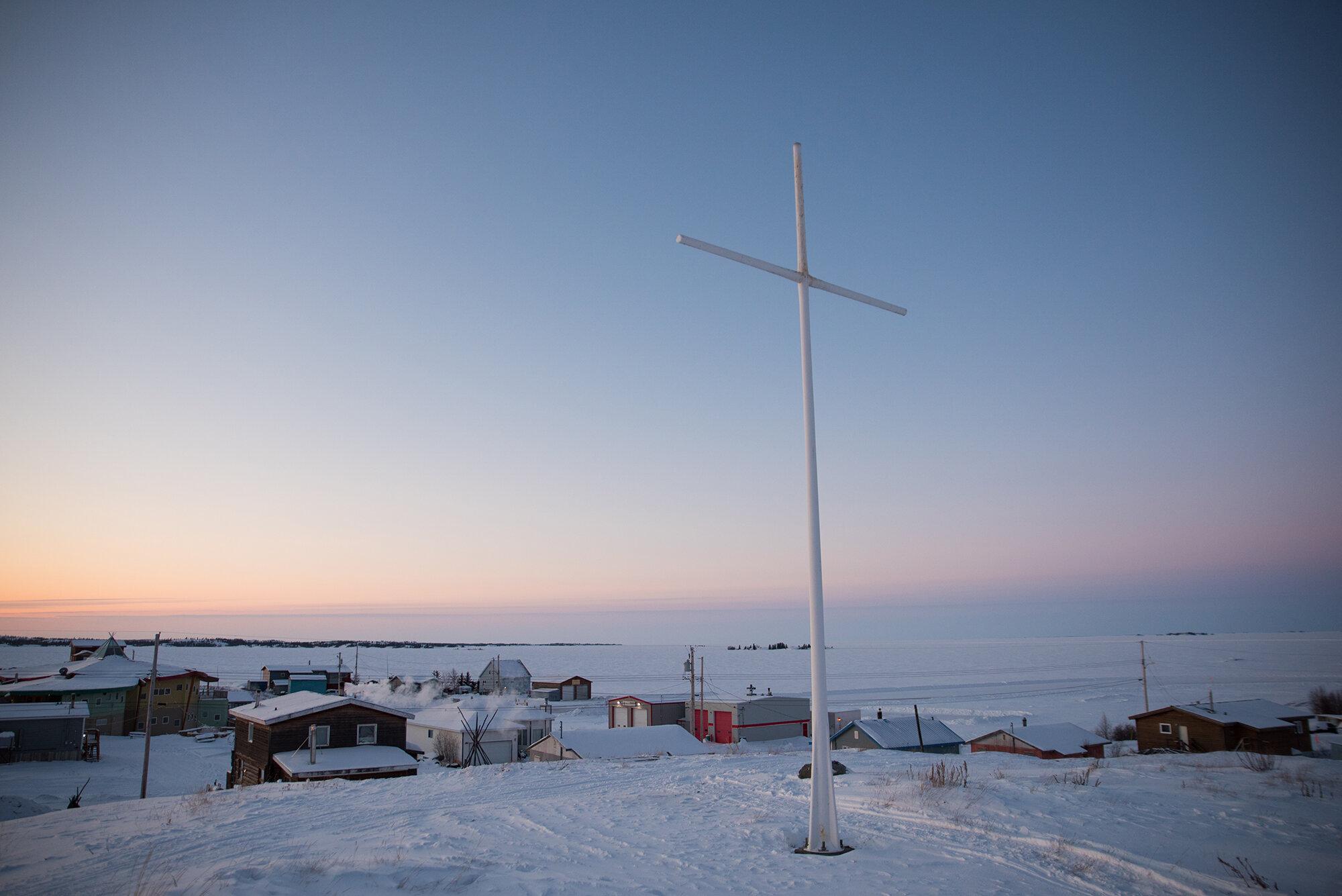 Pandemic Plan - The New York Times - A large white cross sits at the highest point of the Dene...