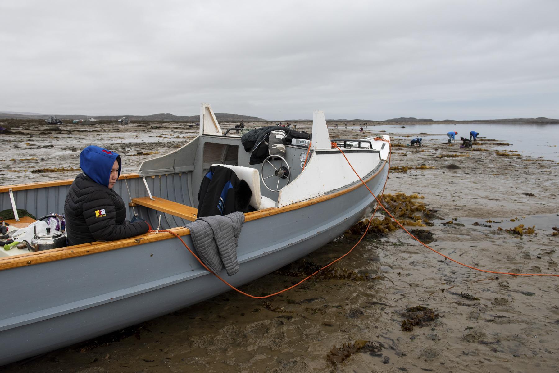 No Place to Grow Old - The Globe and Mail - A woman sits in a boat while Iqaluit residents, including...