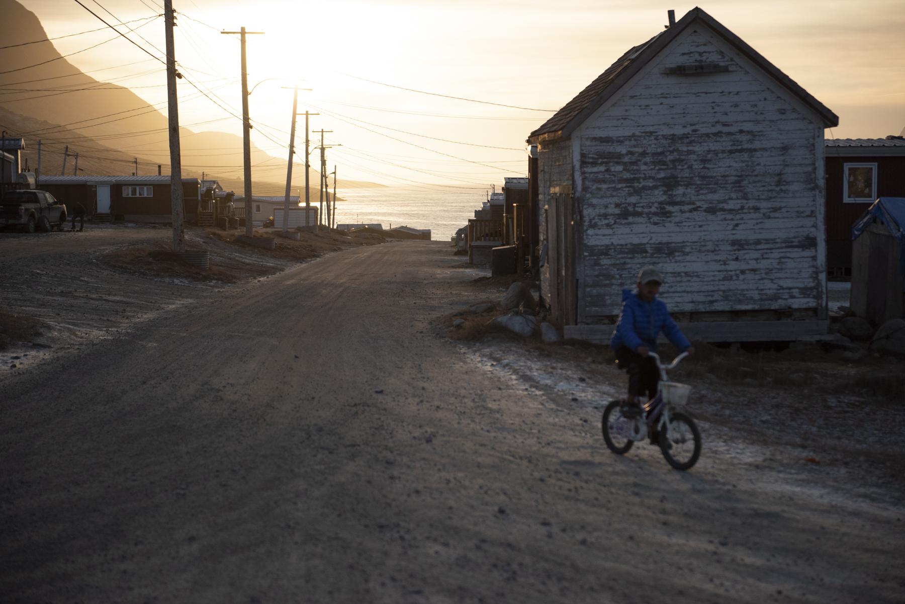 No Place to Grow Old - The Globe and Mail - A boy rides a bike through the streets of Pangnirtung,...