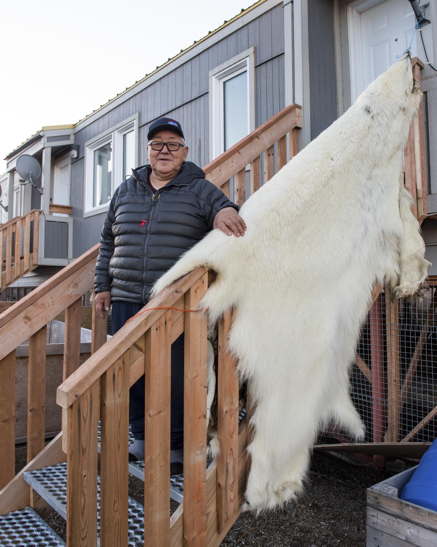No Place to Grow Old - The Globe and Mail - Sandy Akavak stands next to a polar bear hide drying on...
