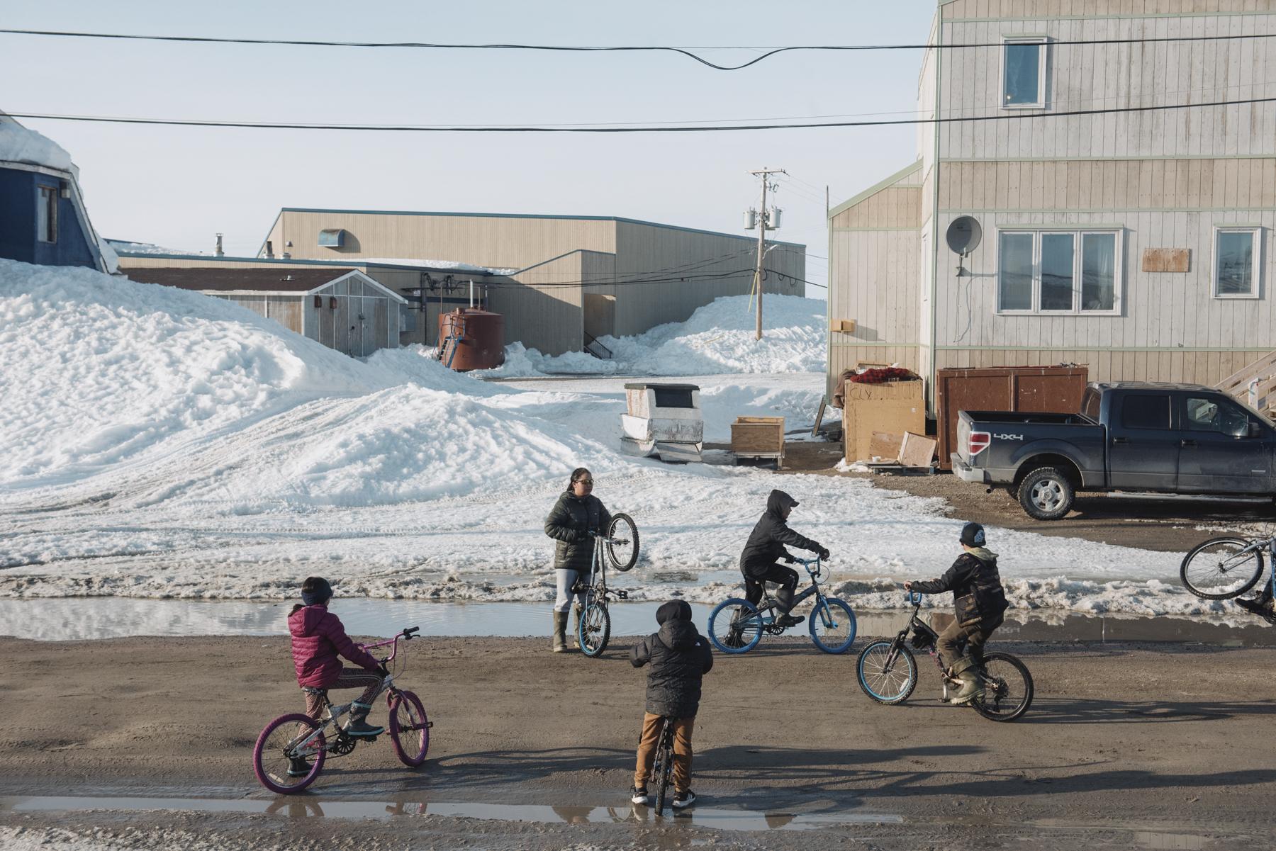 No Place to Grow Old - The Globe and Mail - Kids play on their bikes in Clyde River, Nunavut on May...