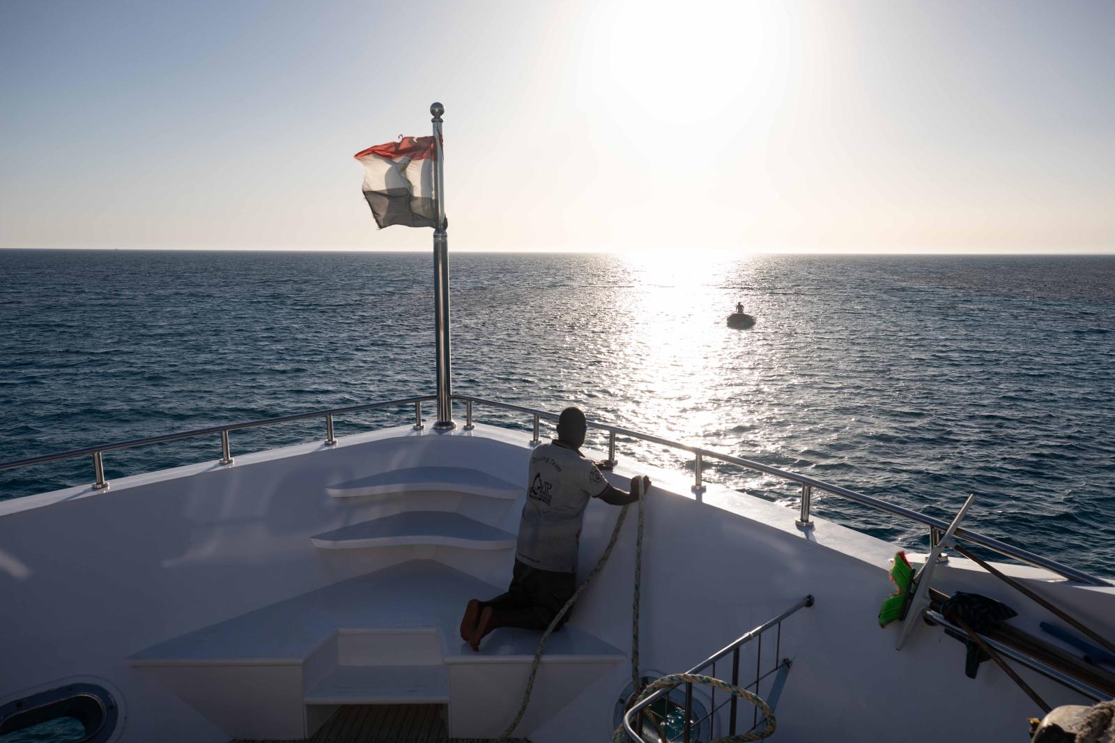 Crew connecting the boat and ex...nchor, which protects the reef.