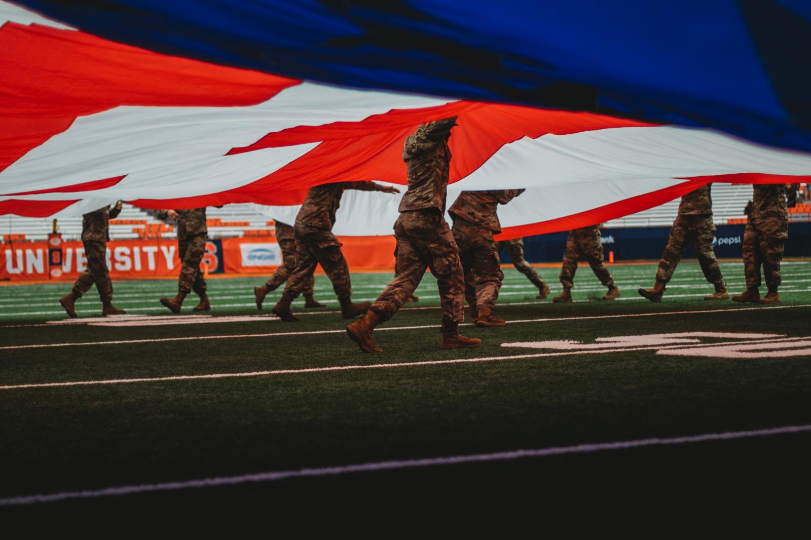 Army ROTC - Syracuse Army ROTC cadets run the big flag along the...