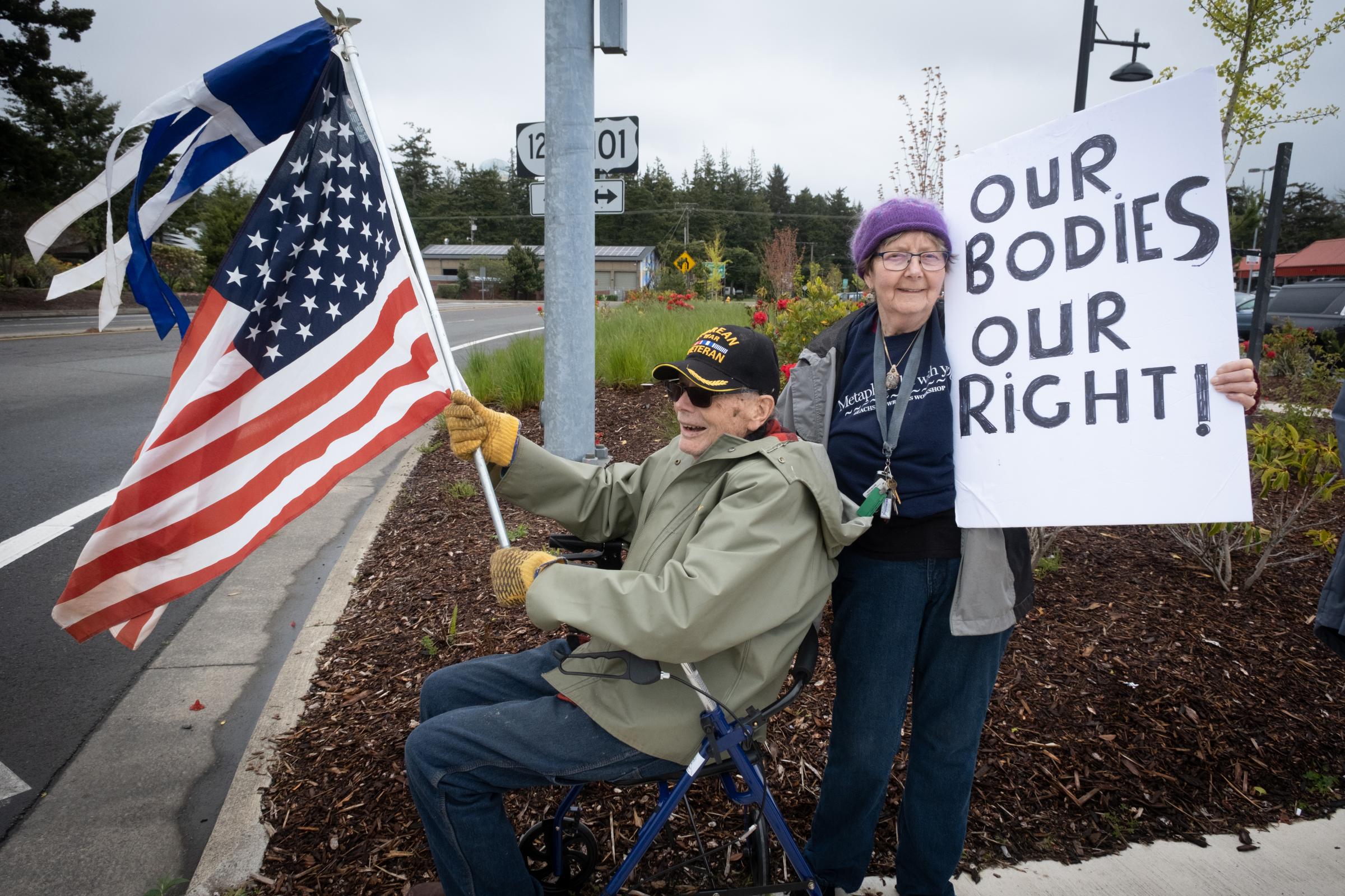 Bans Off Our Bodies Rally Florence Oregon - Veteran with American flag and women with Our Bodies Our Right sign, Bans Off Our Bodies protest,...