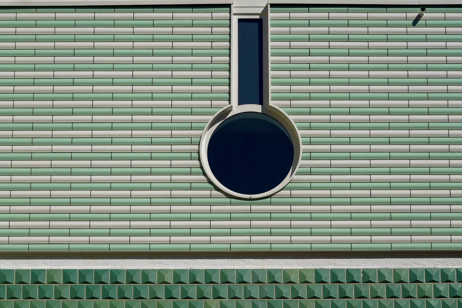 Geometry in Harmony: Circular Window on Tiled Facade | Buy this image