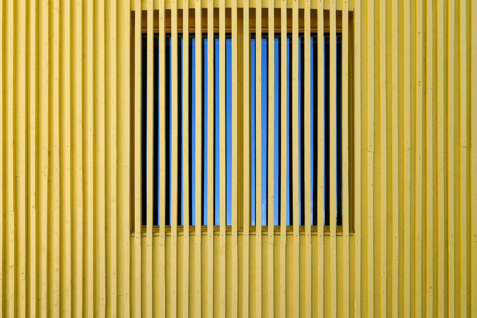 A Glympe of Light: Yellow painted Wood meets blue Sky | Buy this image