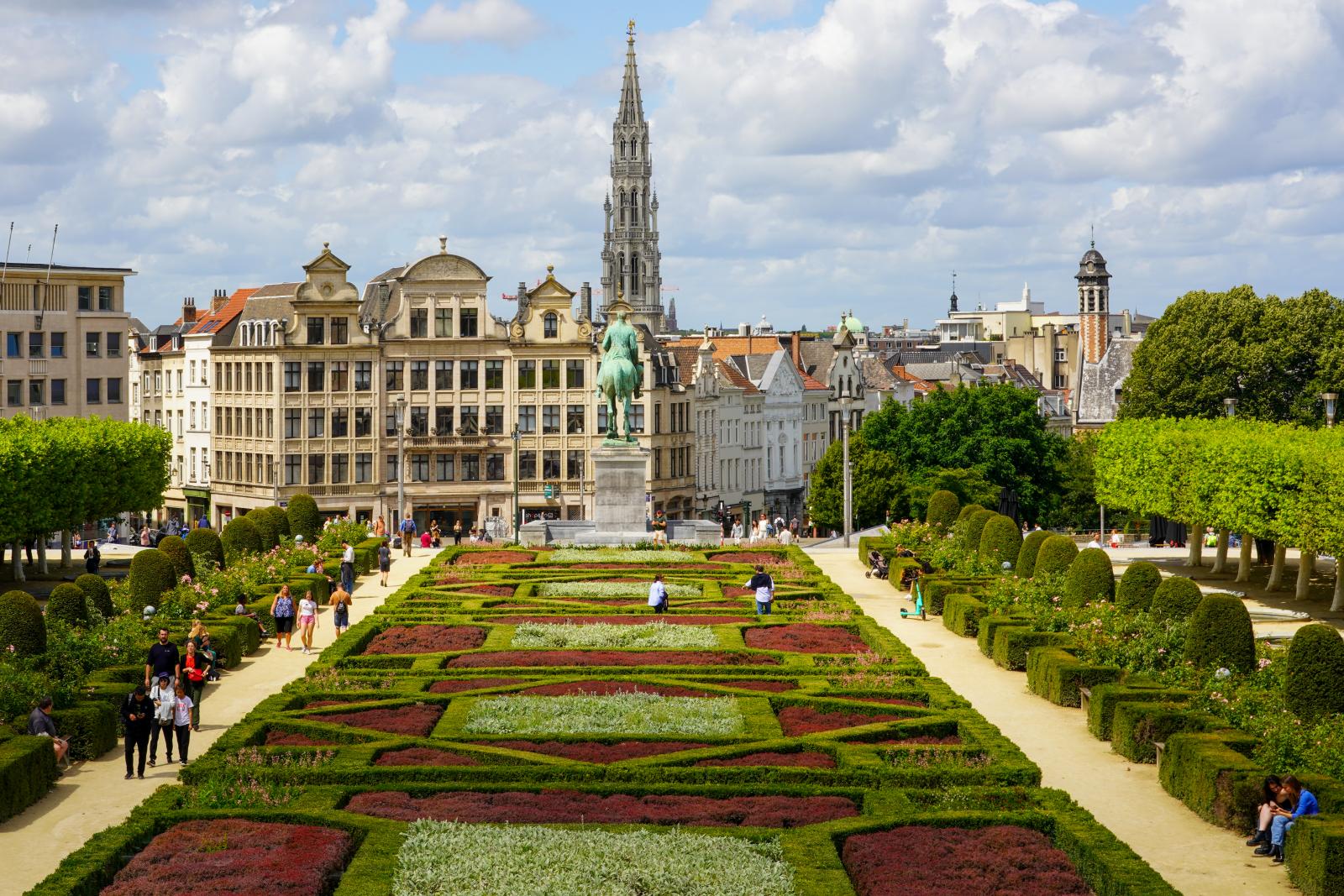 View at the Tower of the Gothic Town Hall of Brussels from the Stairs of the Mont des Arts. People enjoying Time in the Park at the Hill of the Arts