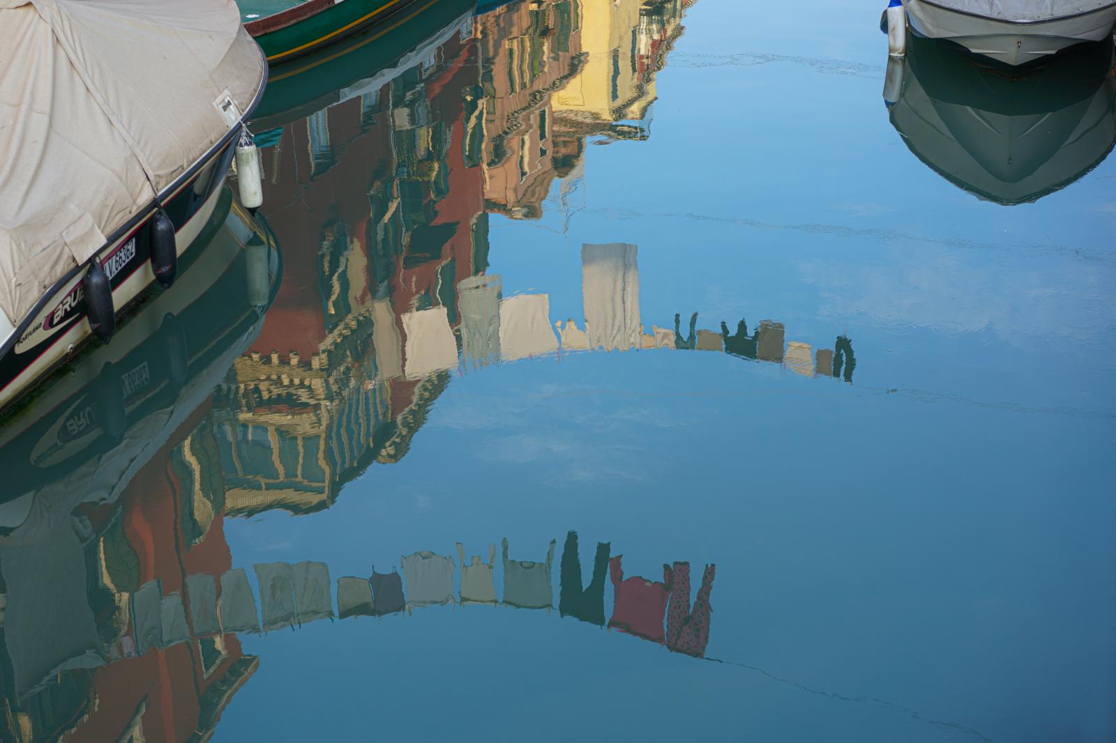 Reflections of Laundry hanging on Clotheslines in the Water of a Canal in Venice