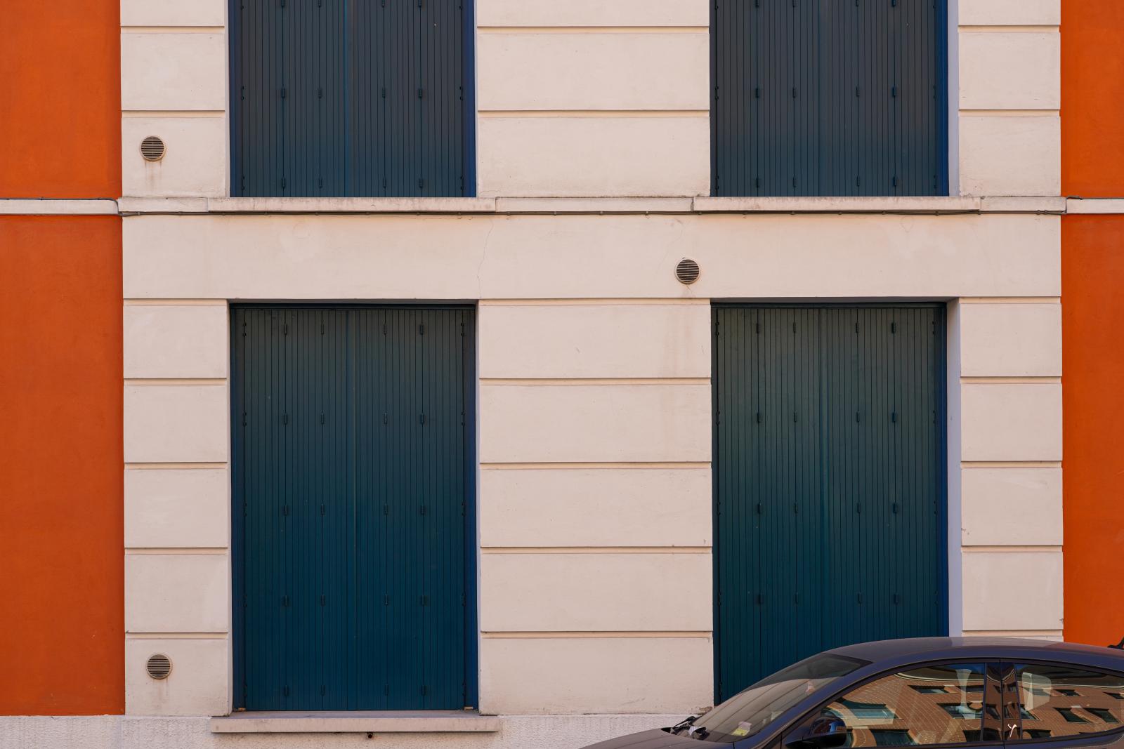 Reflective Repose: Parked Car and Shuttered Windows in Ferrara | Buy this image