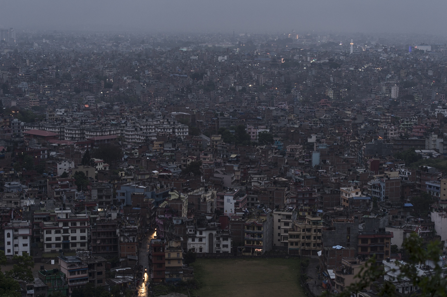 An overview over Kathmandu before sunset shows small, fragmented rays of light in the windows. Restricted use of electricity in the city is...