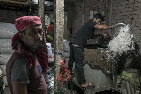 Dangerous job of recycling - Two men work cutting plastics on machines in a small makeshift warehouse in Old Dhaka. Thousands...