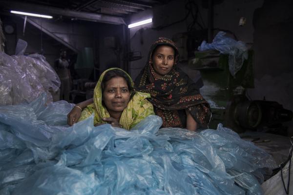 Dangerous job of recycling - Two women who work in a small recycling factory in the center of Old Dhaka rest on a mountain of...