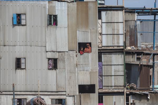 Dangerous job of recycling - A woman and her daughter look out the window of a building in the Old Dhaka neighborhood....