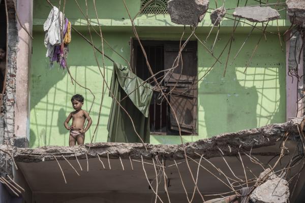 Dangerous job of recycling - A girl looks out from the ruins of her house in the Islamabag neighborhood in Old Dhaka where...