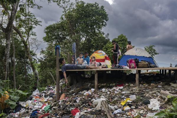 The journey trough Darien Gap - A family of Venezuelan migrants rests on top of a hill in the Darien jungle. On a dump created by...