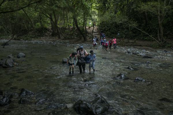 The journey trough Darien Gap - A family of Chinese origin crosses one of the Pinololo rivers during their journey through the...