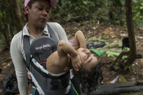 The journey trough Darien Gap - Alejandra blows a little air on her little son Zair to try to relieve him of the sweltering heat...