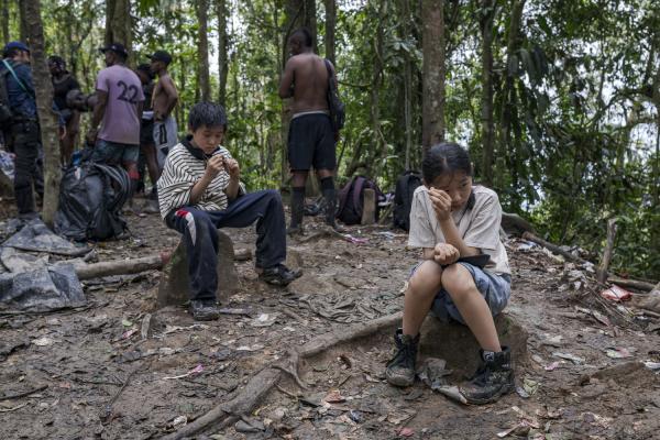 The journey trough Darien Gap - A couple of children of Chinese origin rest on the border between Panama and Colombia. your...