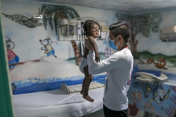 Between conflict and water, the hospital ship of the Pacific Region of Colombia - A doctor from the "San Rafaelle" Hospital Ship treats a little girl from the community....