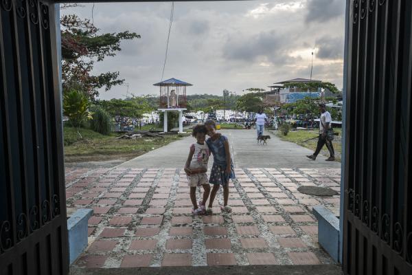 Between conflict and water, the hospital ship of the Pacific Region of Colombia - Two girls pose for a photograph at the entrance of the Puerto Saija church, behind them an armed...