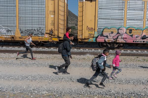 La tortuosa travesía, la migración a través de América. - A family of migrants runs to board the train known as &quot;The Beast.&quot; Huehuetoca,...