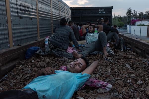 La tortuosa travesía, la migración a través de América. - A man rests on a bed of rusty metal. He is a migrant traveling on &quot;The Beast&quot;...