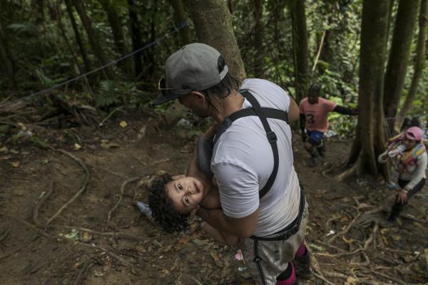 The tortuous journey, the migration through America - Horacio carries his little son Zamir in his arms while they cross the Darien Gap. In the first...