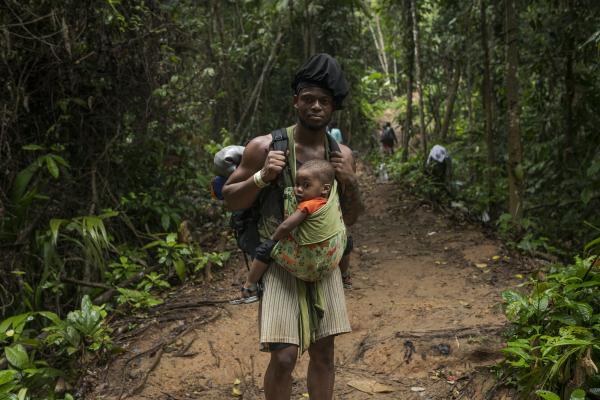 The tortuous journey, the migration through America - A man of Haitian origin, poses for a portrait. in her arms she carries her little son. Both are...