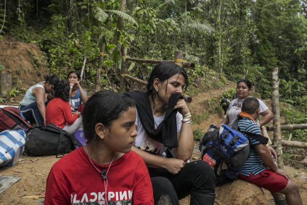 The tortuous journey, the migration through America - A group of migrants take a short break after walking for several hours through the Darién Jungle...