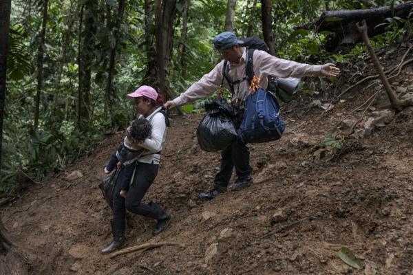 The tortuous journey, the migration through America - As they descend a hill, Alejandra and her little son Zair are helped by another migrant....