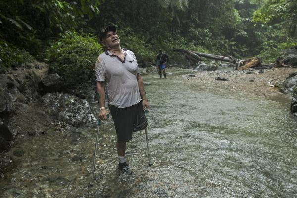 The tortuous journey, the migration through America - Manuel poses for a portrait on the bed of the Pinlolo river. Under heavy rain and walking with...