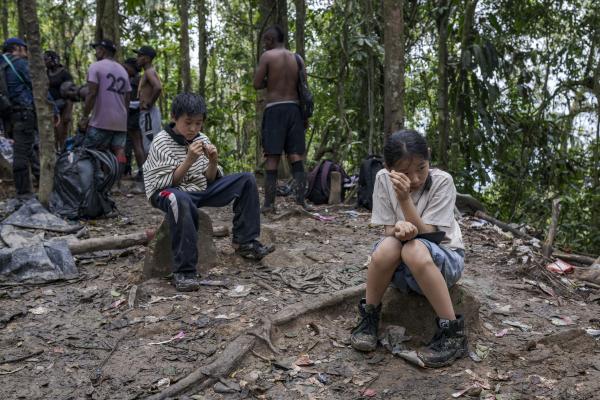 The tortuous journey, the migration through America - A couple of children of Chinese origin rest on the border between Panama and Colombia. your...