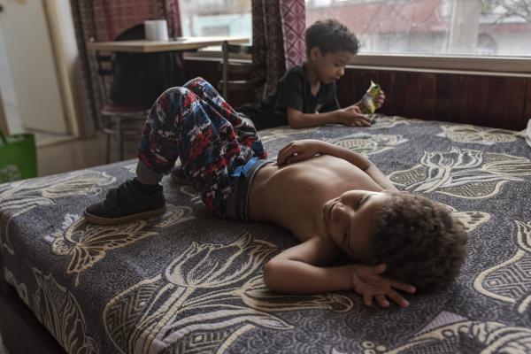 The tortuous journey, the migration through America - Little Mathias and Mauricio rest in a hotel room in Hueuetoca, a town on the outskirts of Mexico...