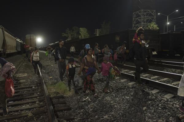 The tortuous journey, the migration through America - Dozens of migrants walk on the train tracks at dawn. They seek to board another train that will...