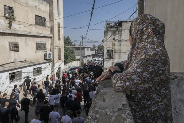 Funeral in West Bank - A woman watches a group of men carry the body of Ibrahim Zayad towards the Qualandya cemetery....