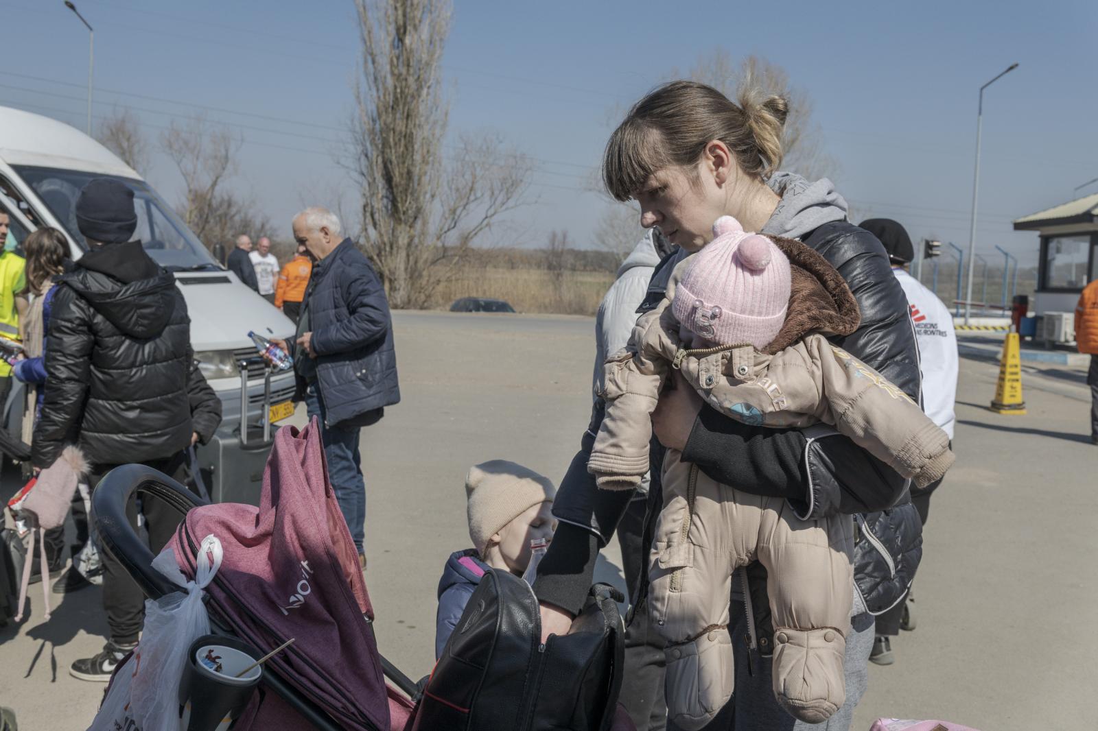 Una mujer con su hija en brazos acaba de cruzar la frontera.