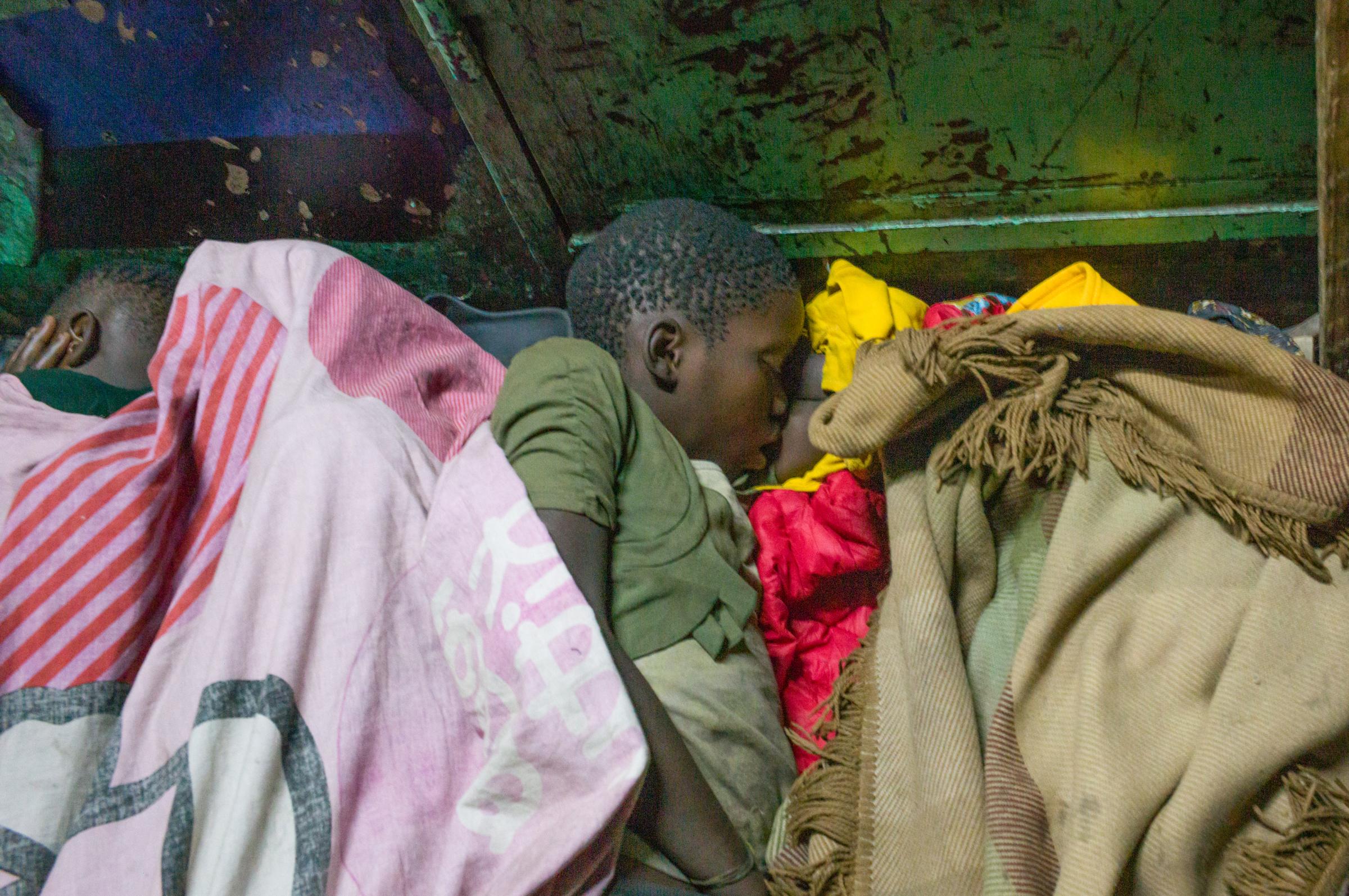 Life on the street in Lusaka - A 3 year old girl lies buried in the blankets (in the yellow). She probably has an older sibling...