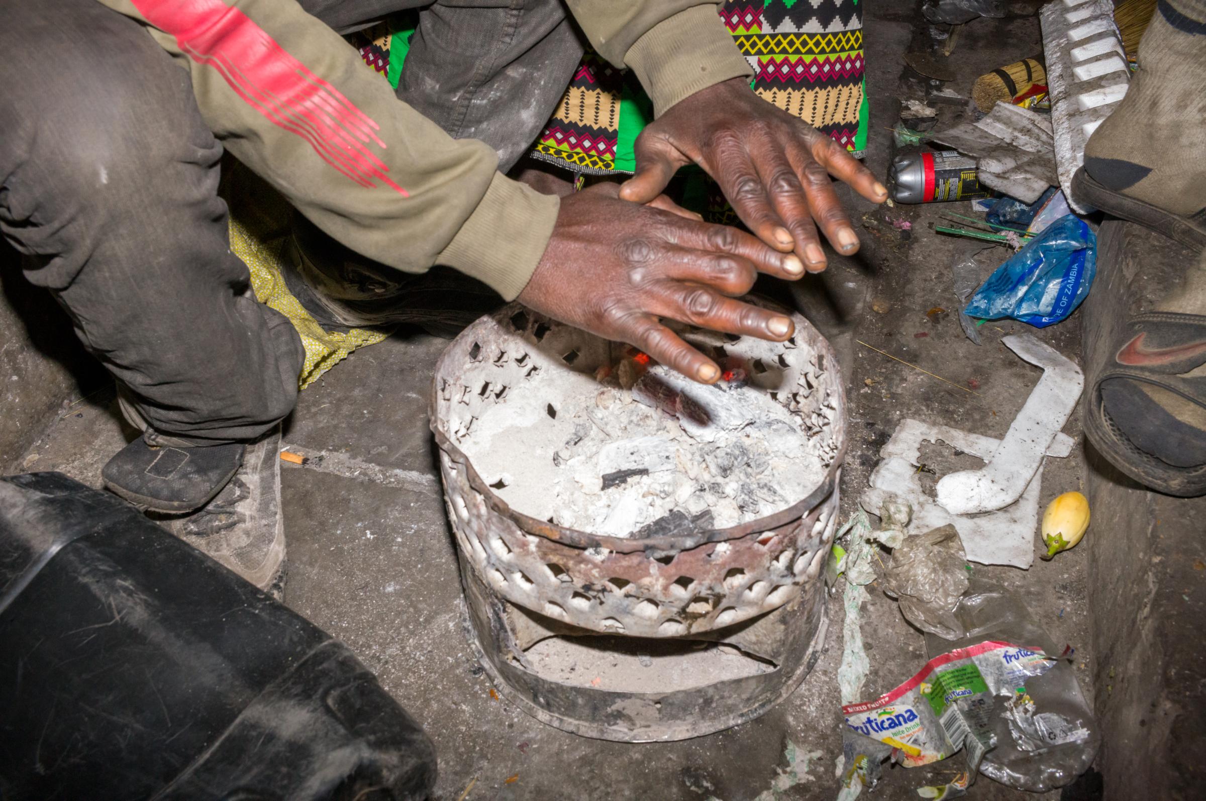 Life on the street in Lusaka - Keeping warm over the embers of the brazier, these hands could tell a story.