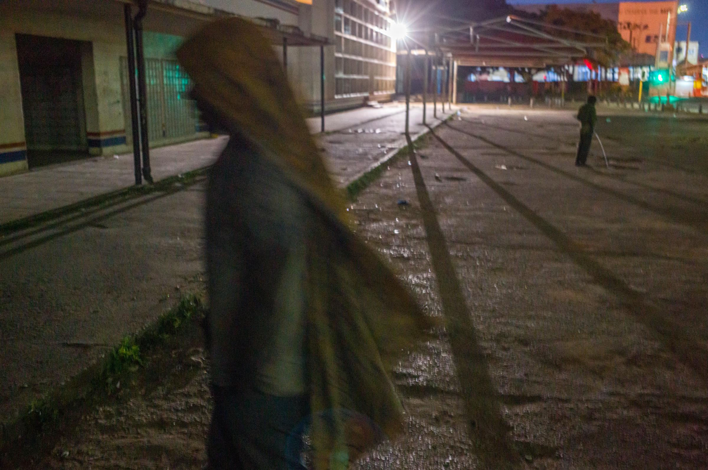 Life on the street in Lusaka - 3am A boy comes out of the underpass to relieve himself as another man carries his blanket on his...