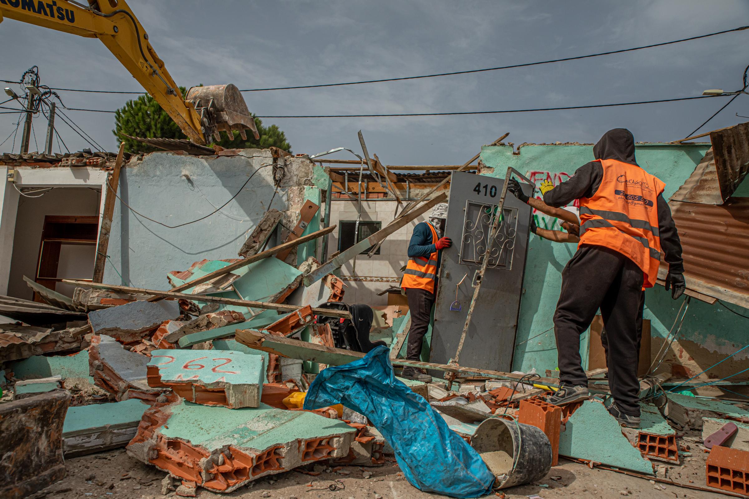 The Aftermath 2º Torrão - Workers help residents save some of the materials from...