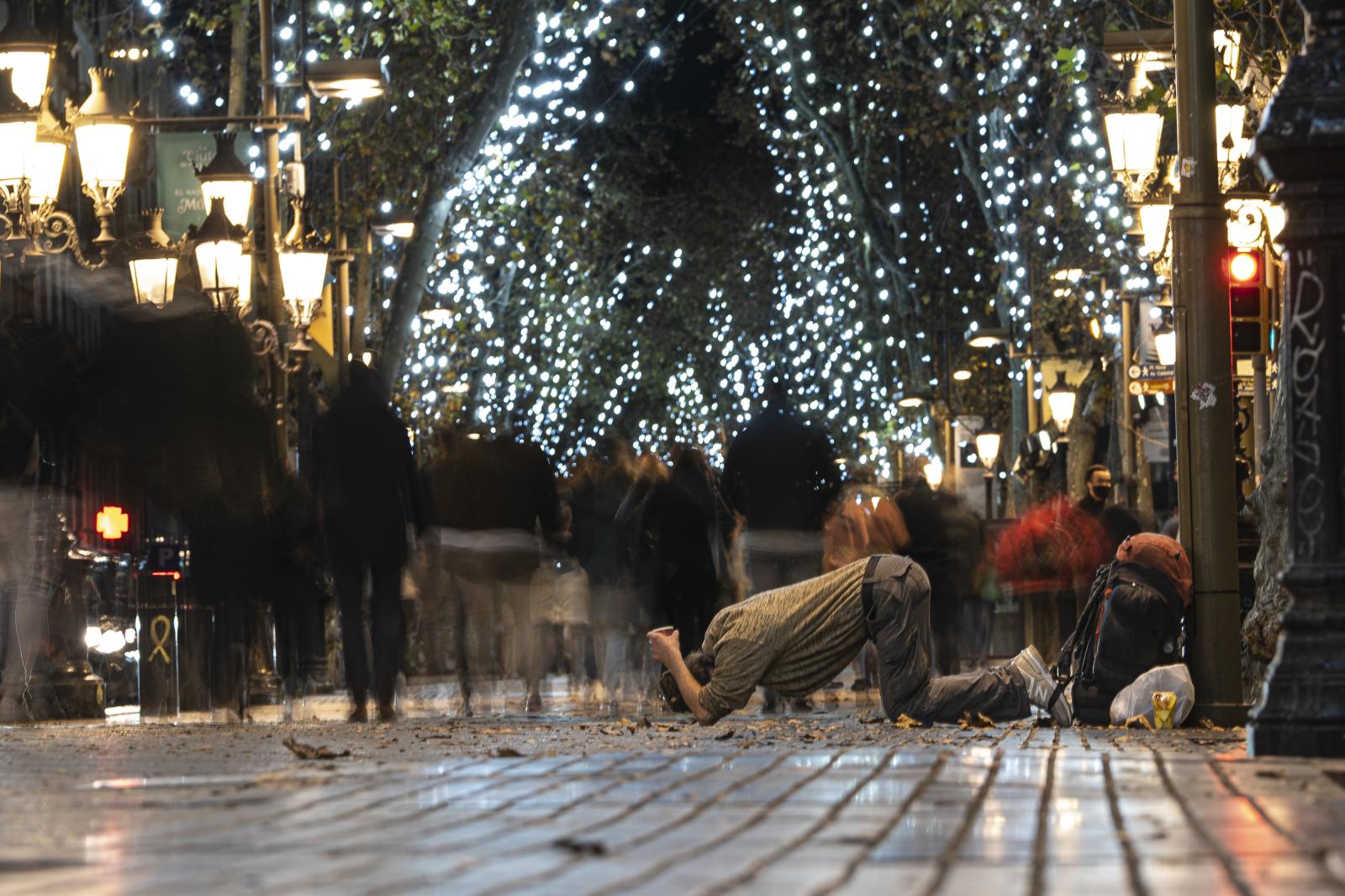 DAILY NEWS - A homeless person begs for alms on the Ramblas of...