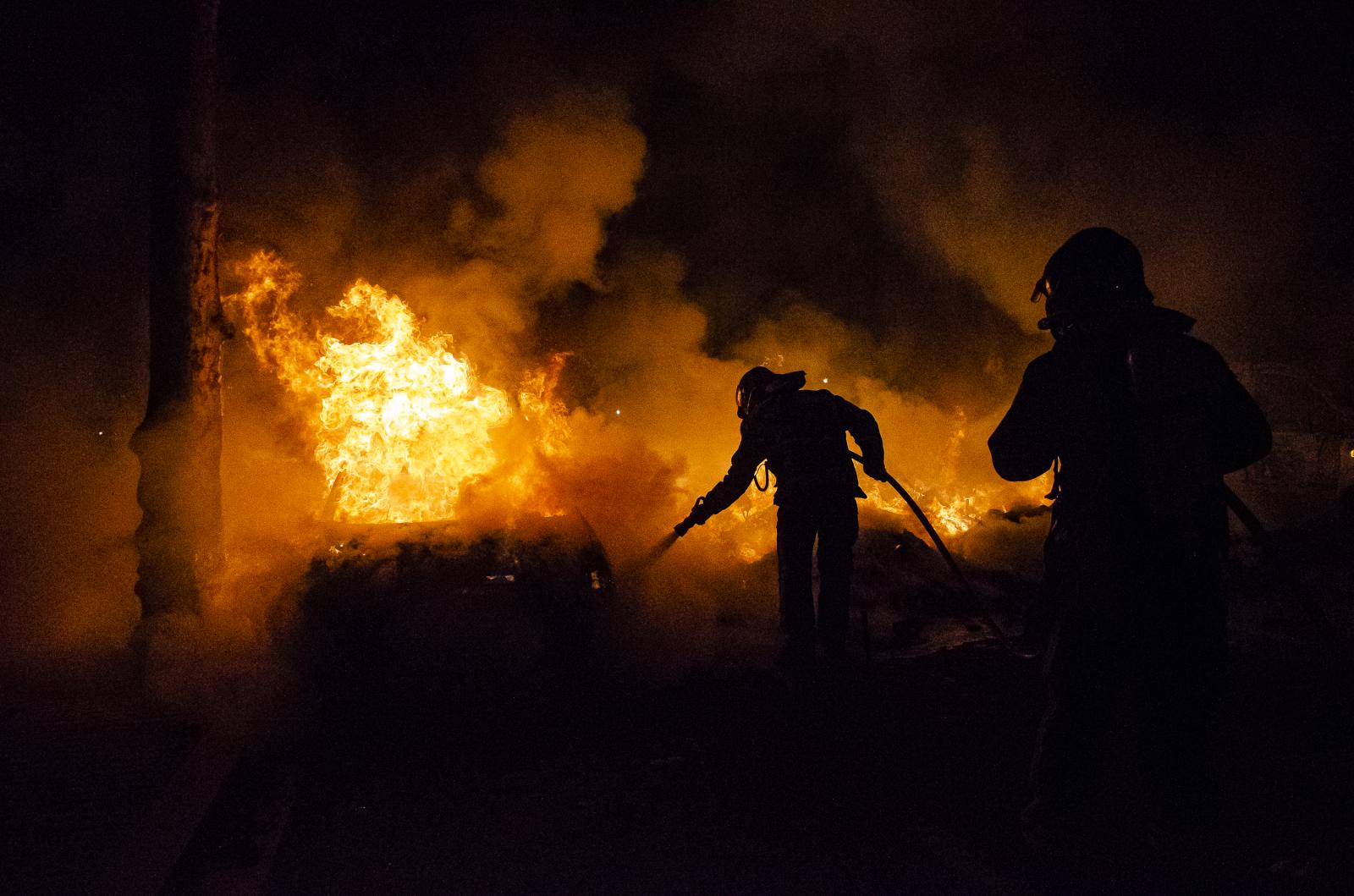 Image from DAILY NEWS - Firefighters work to extinguish several cars on fire due...