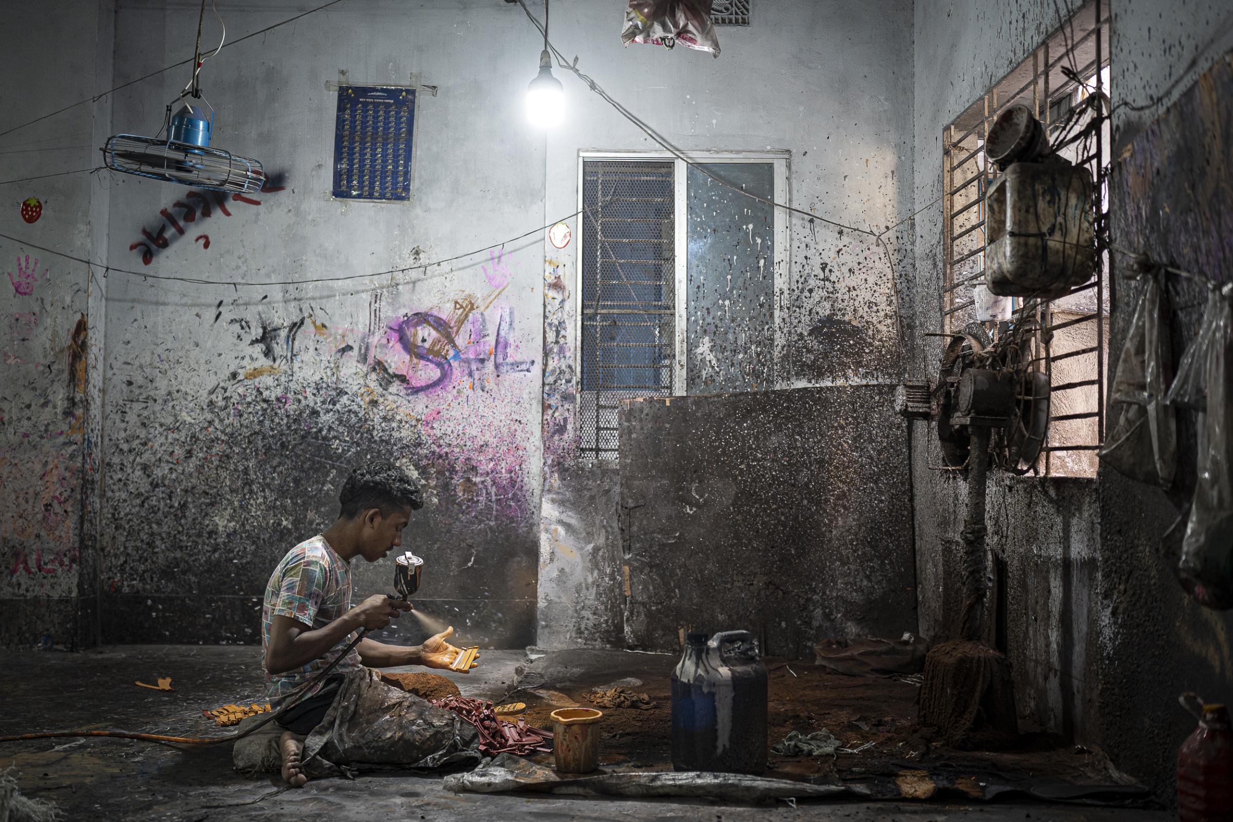 Beyond the storm - A worker in a recycled shoe factory in the Lalbagh...
