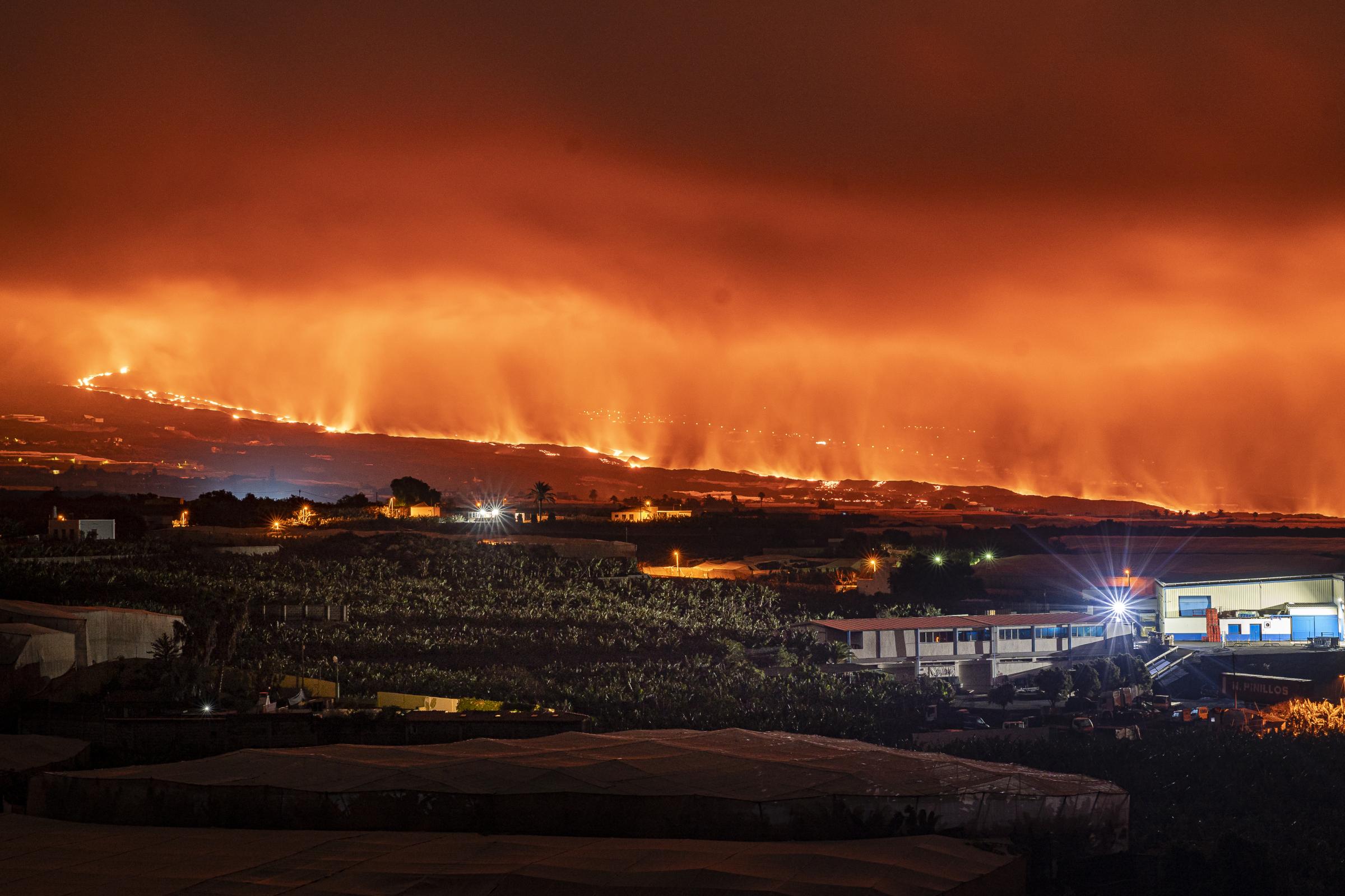 In the background of the picture, the lava flow stains the sky a very intense orange colour. In...