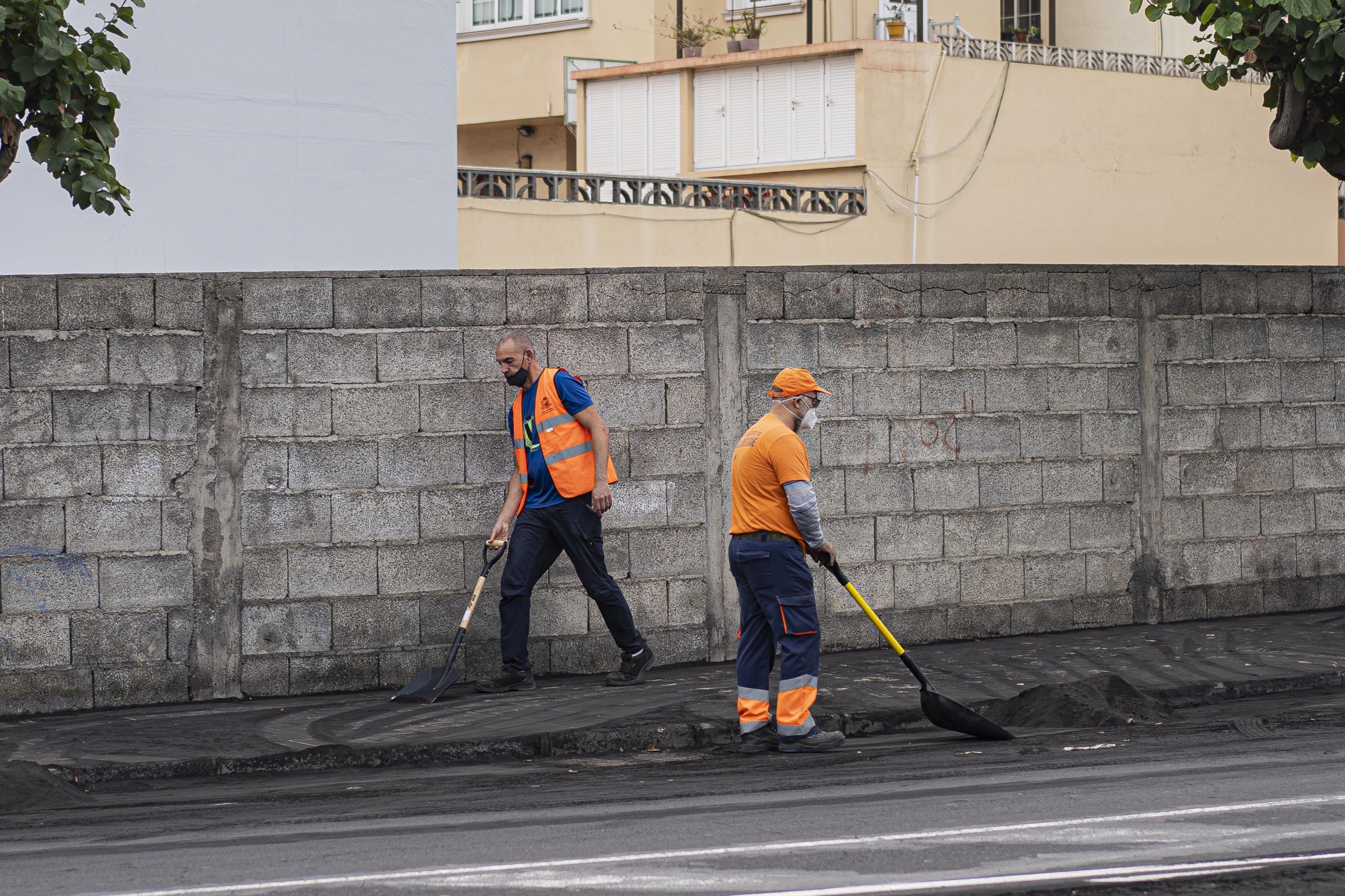 Volunteers remove accumulated ash from the streets of Los Llanos, La Palma island.